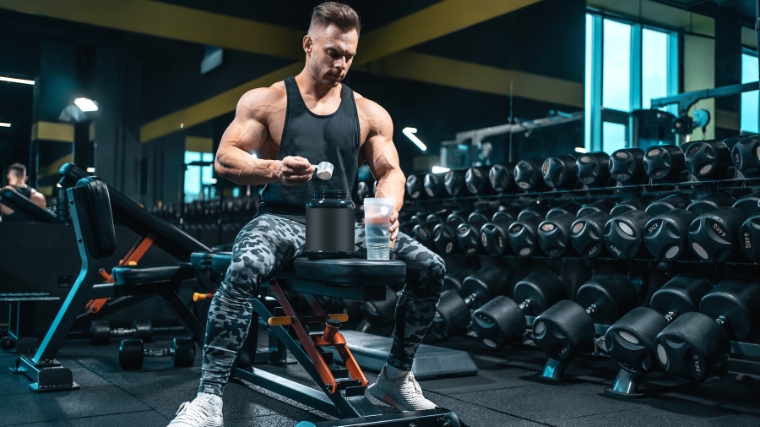 A person scooping creatine powder into s container.