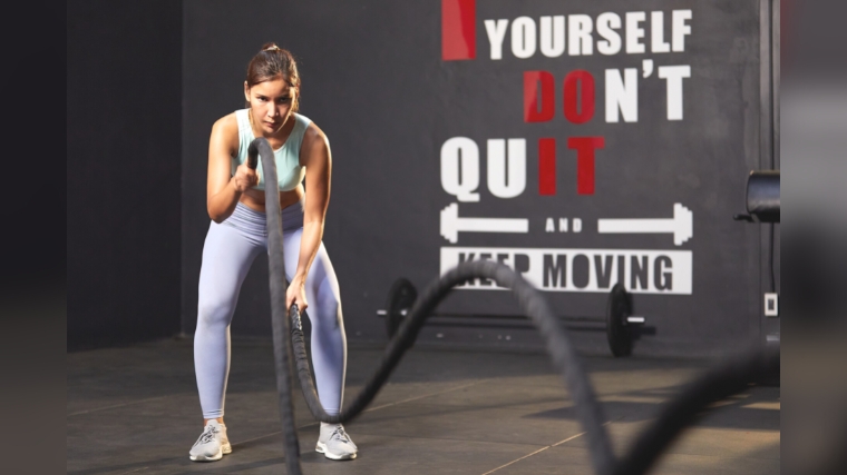 A person working out with ropes in a CrossFit box.