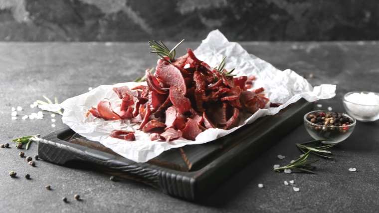 A serving of meat jerky on a plate.