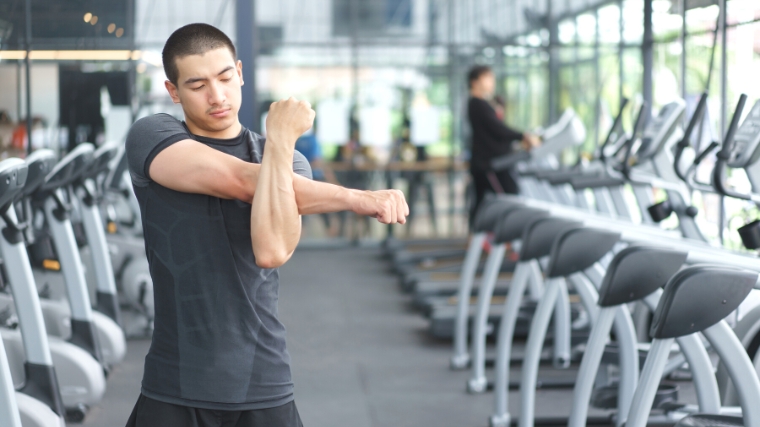 A young person stretching in the gym.