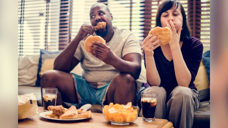 Two people eating on their cheat day.