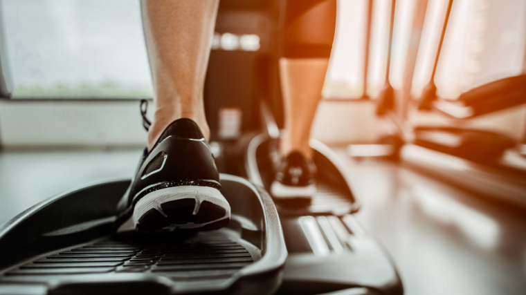Close-up of person's lower body working out on elliptical