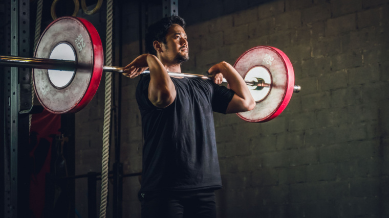 A person performs a barbell front squat.