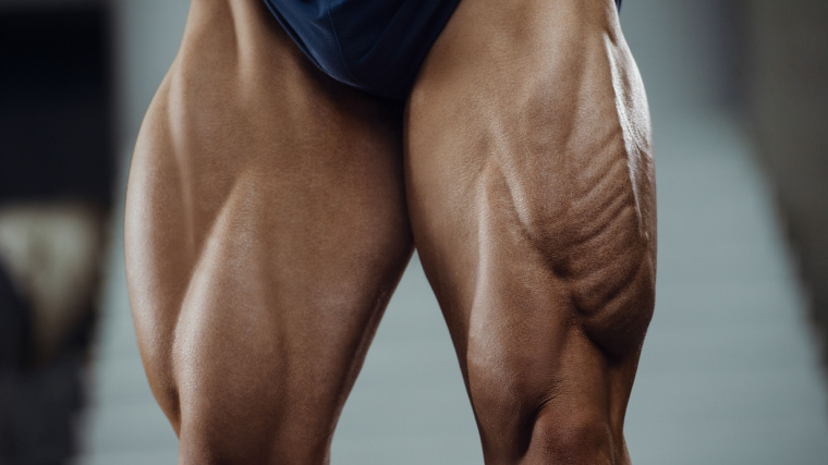 Man flexing muscular quads in gym