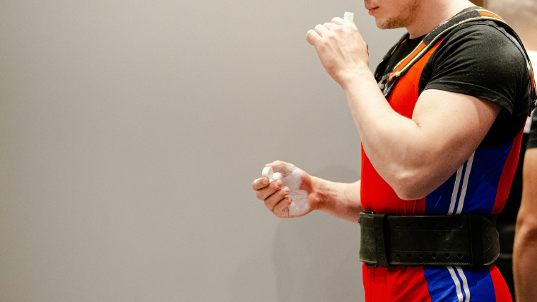 A powerlifter ingests smelling salts before lifting