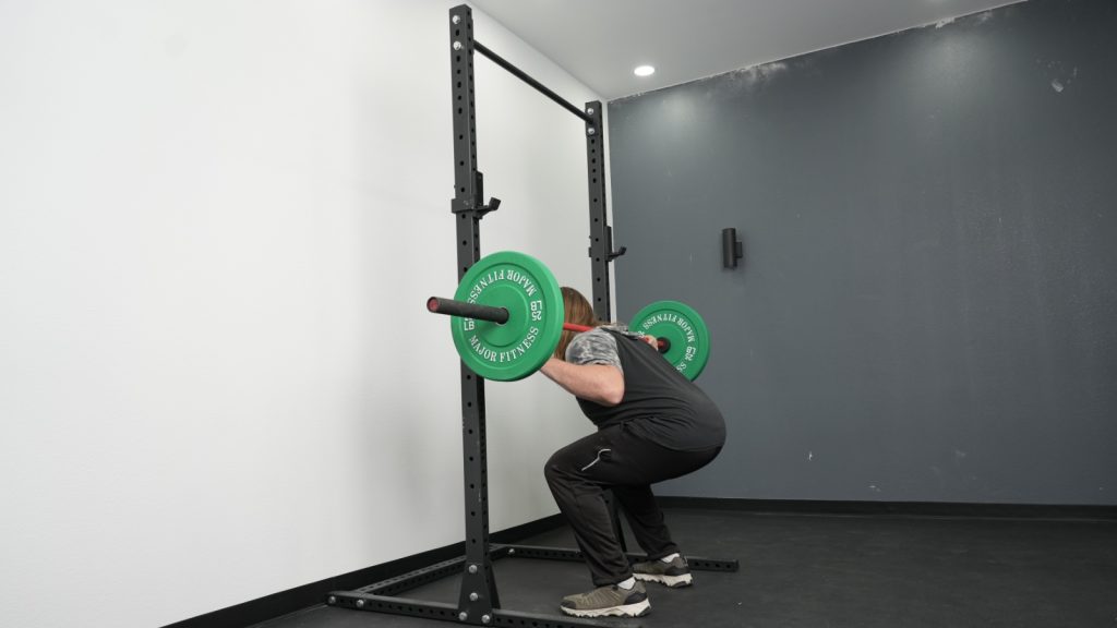 A person squatting with the Fringe Sport Unlimited Squat Stand with Pull-Up Bar.