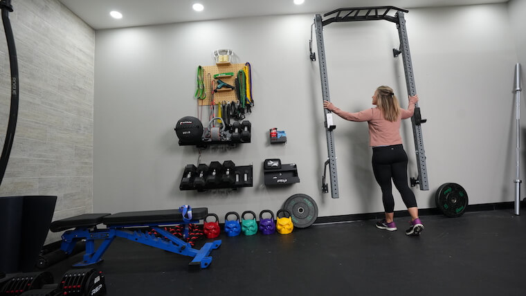 A person mounting the PRX Profile Pro Folding Squat Rack.