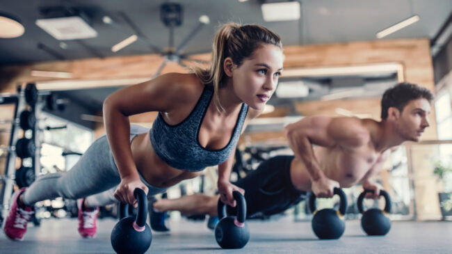 Two women working out in the gym.