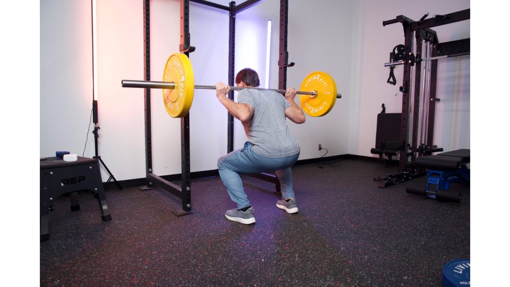 A person squatting with the Titan T3 Squat Cage.