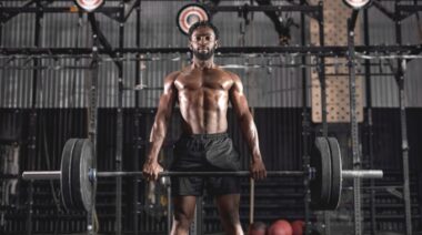 A person holding a barbell in the gym to exercise,