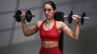 A person ready to perform the dumbbell shoulder press.