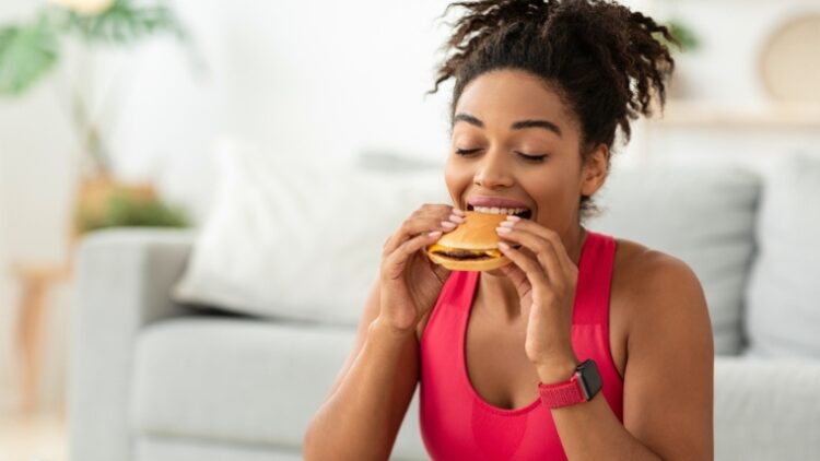 A person having a burger on cheat day.