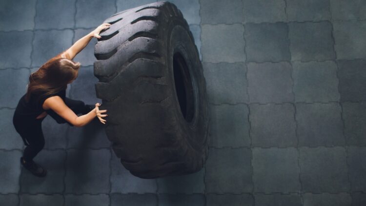 A person performing a tire flip.