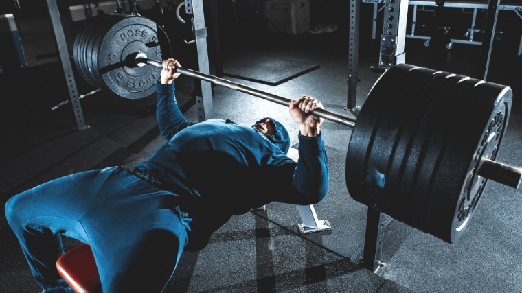 A person doing a barbell bench press.