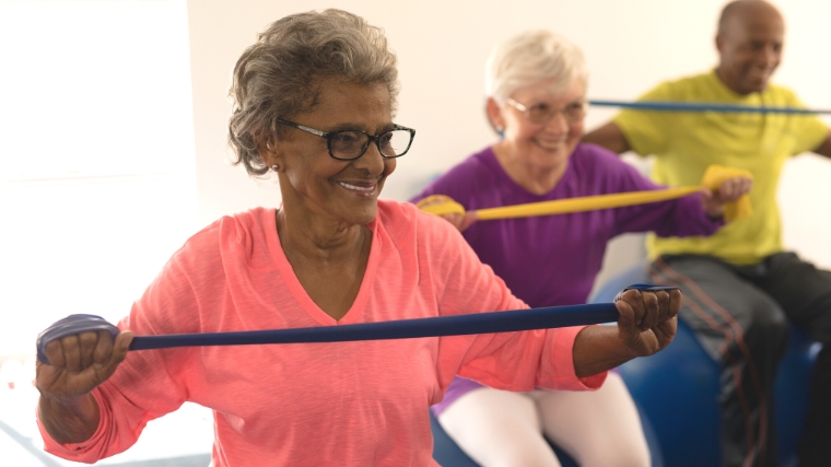 Elderly people exercising with resistance bands.