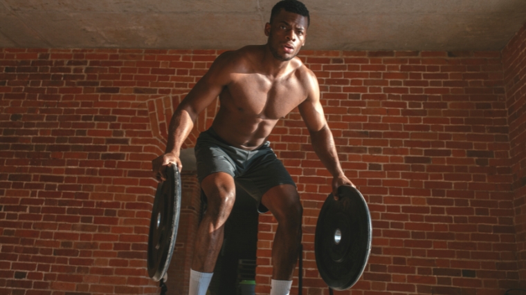 A person training with weight plates in both hands.