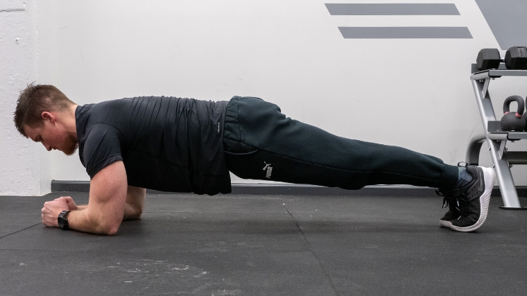 A person doing a plank on their elbows.