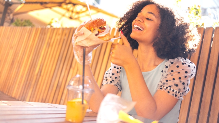 A person eating burger and fries during their monthly period.