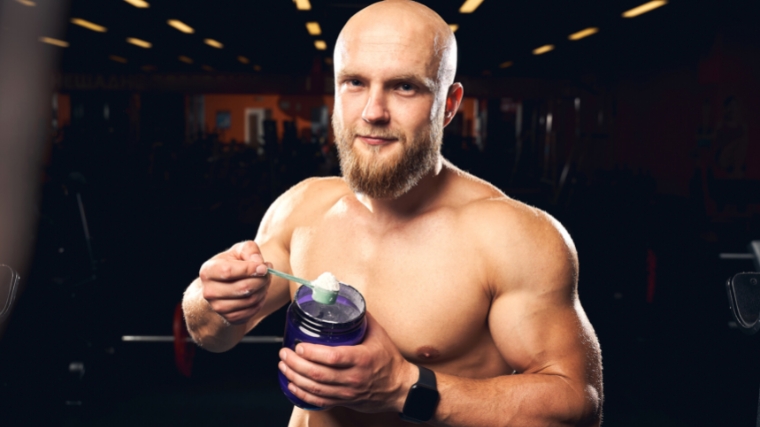 A person scooping powder from supplement container.