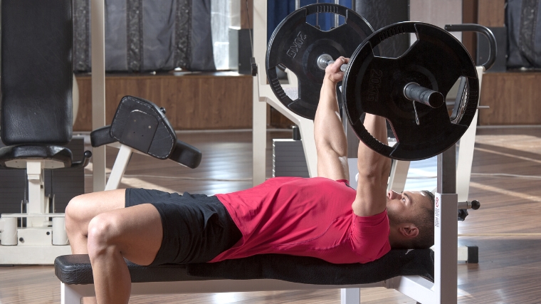 A person performing a barbell bench press.