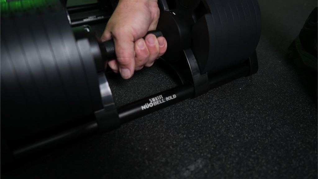 Grabbing onto the handle of the SMRTFT Nüobell Adjustable Dumbbell