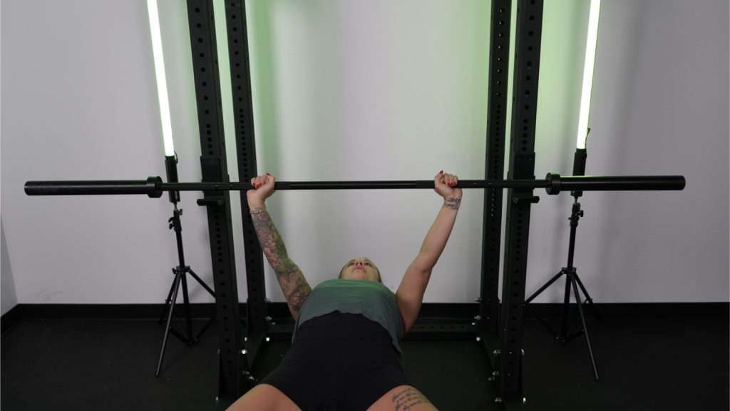 A woman bench-pressing on Rogue HR-2 Half Rack