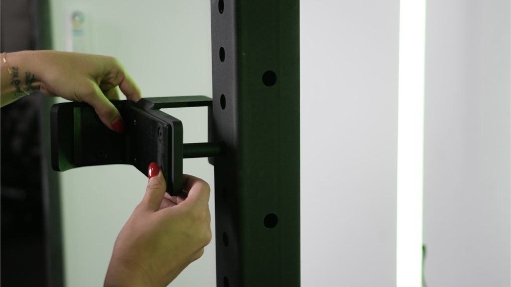 A person adjusting J-hook on Rogue Half Rack