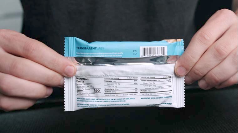 Person holding Onnit Protein Bites package and displaying the label