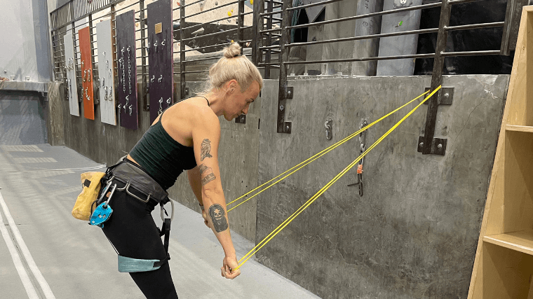 Woman warms up shoulders with a resistance band