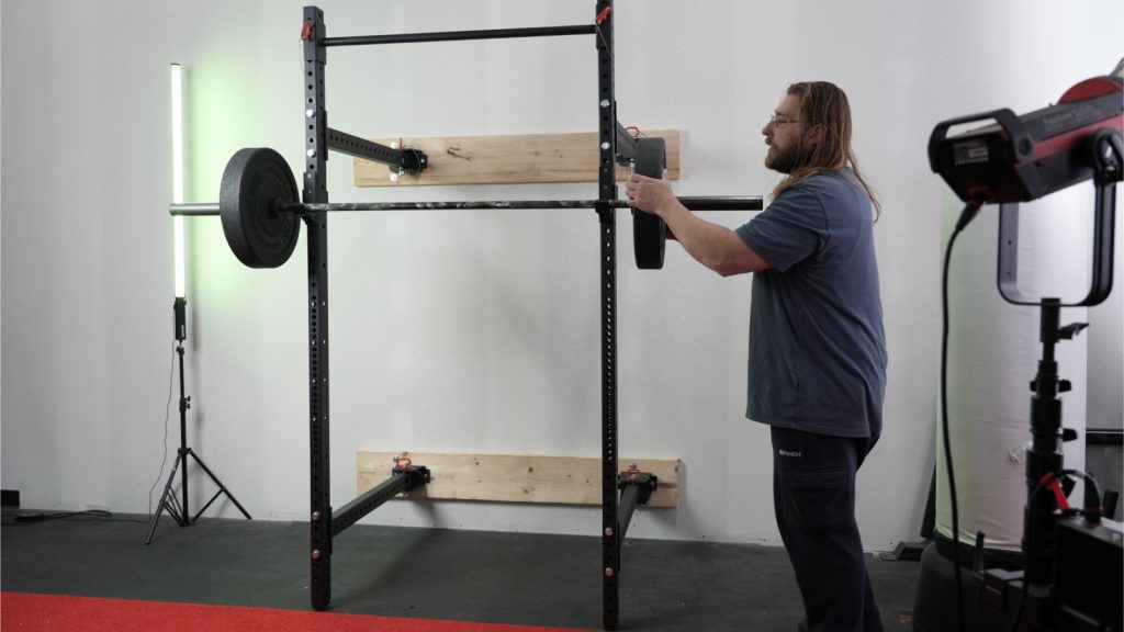 Person loading barbell on Titan T3 folding rack