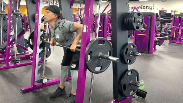 A person doing a bent-over row using on a Smith machine.