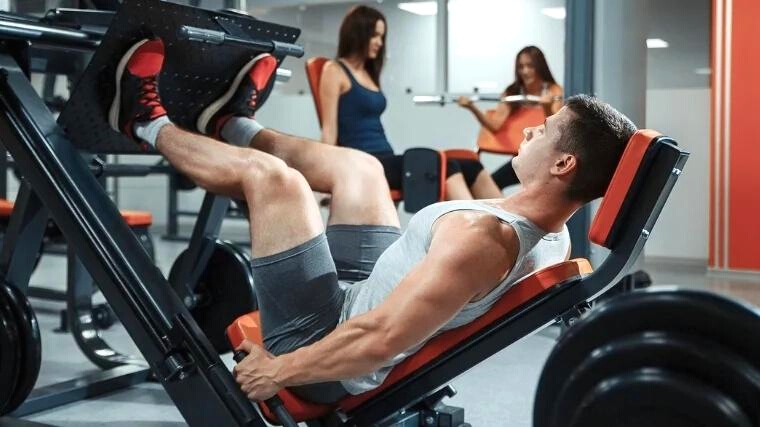A person doing leg workout on a gym equipment.