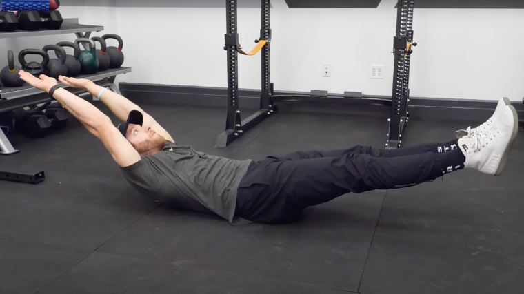 A person doing the hollow hold exercise.