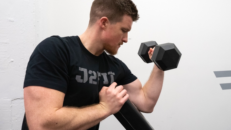 A person in a black shirt working on his biceps.