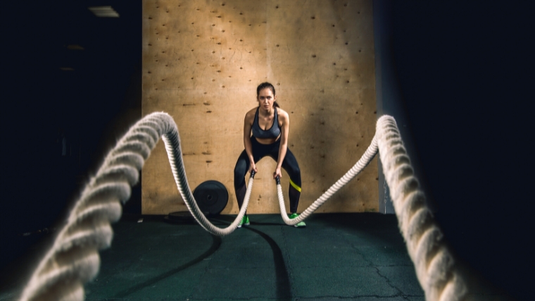 A person working out with battle ropes.