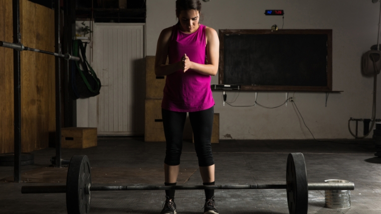  A woman about to lift a barbell.