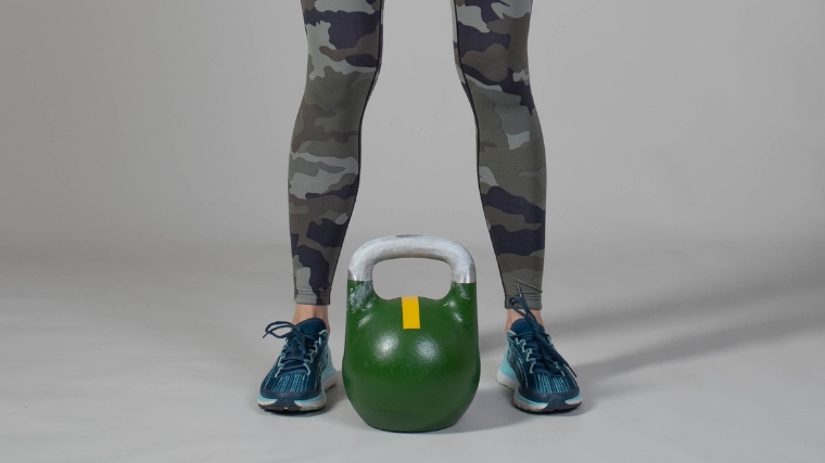 Kettlebell deadlift - first step, with the kettlebell positioned between a person's feet.