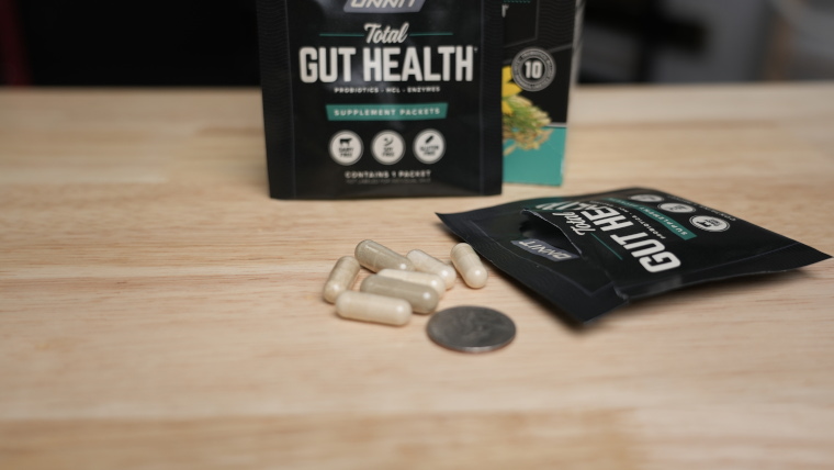 Onnit Total Gut Health capsule next to a quarter for size comparison
