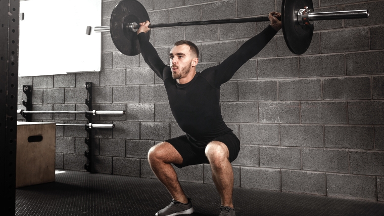 A person squatting with a barbell.