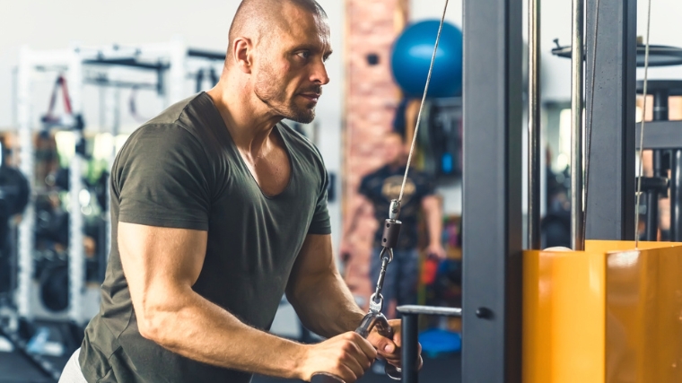 A person working out using a cable machine.