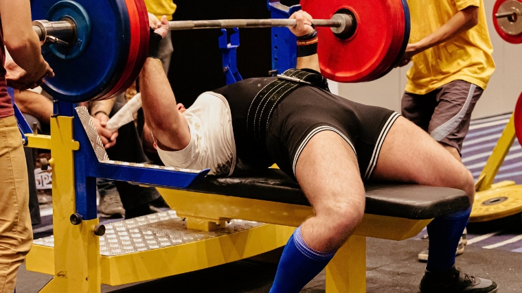  A powerlifter bench pressing a in a competition.