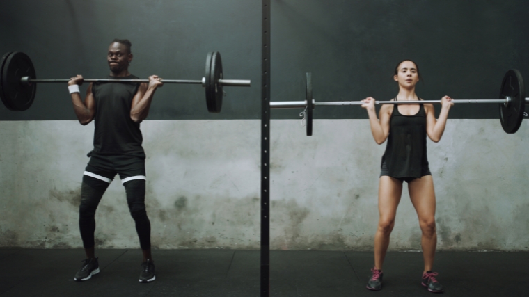 Two people lifting a barbell.