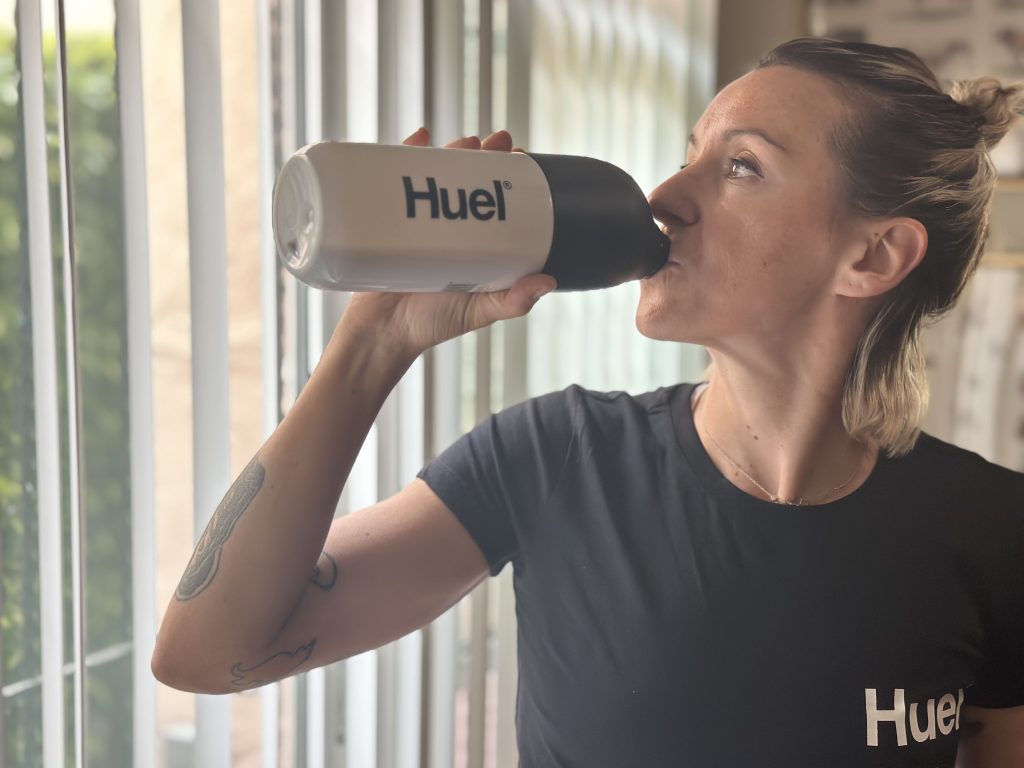 A BarBend tester drinking a Huel Black Edition smoothie.