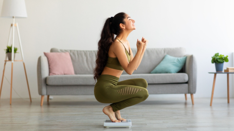 Woman celebrates her weight change goal on scale