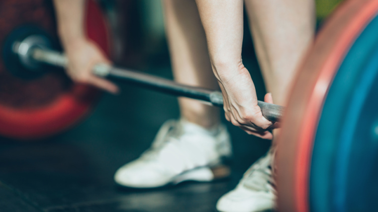 Athlete uses hook grip on loaded barbell while wearing lifting shoes