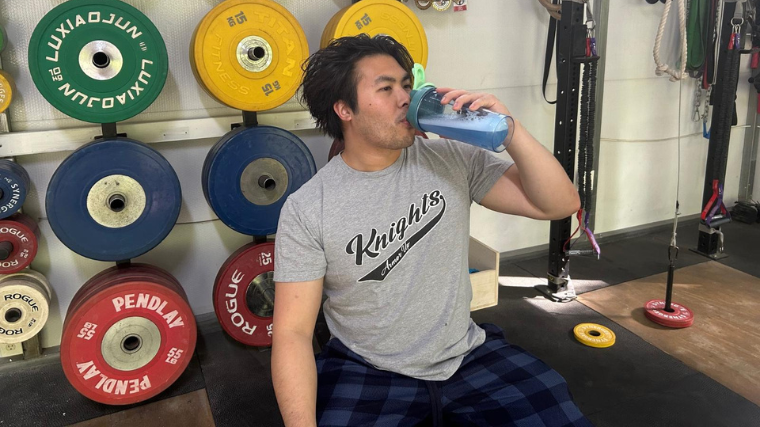 A person drinks Nutricost Pre-X Pre-Workout in the gym.