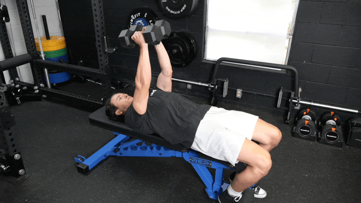 A person doing the dumbbell flye on a flat bench.