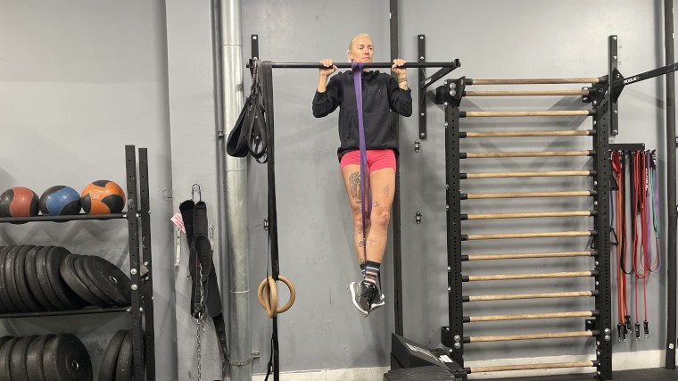 Our BarBend Tester doing assisted pullups with one of the Fringe Sport Resistance Bands.