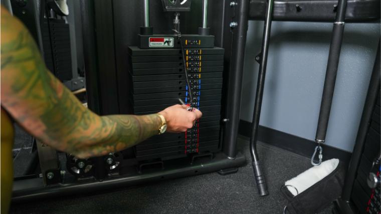 Our tester adjusting the weight on the Gronk Fitness Functional Trainer.