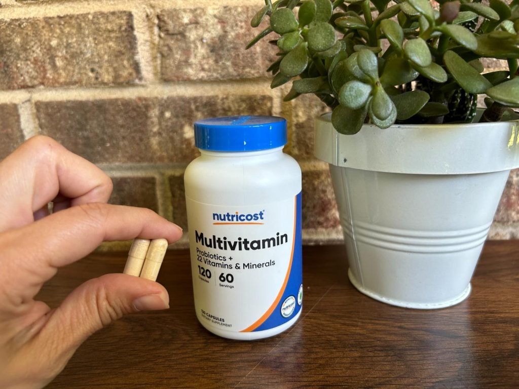 Two Nutricost Multivitamin capsules with the bottle.